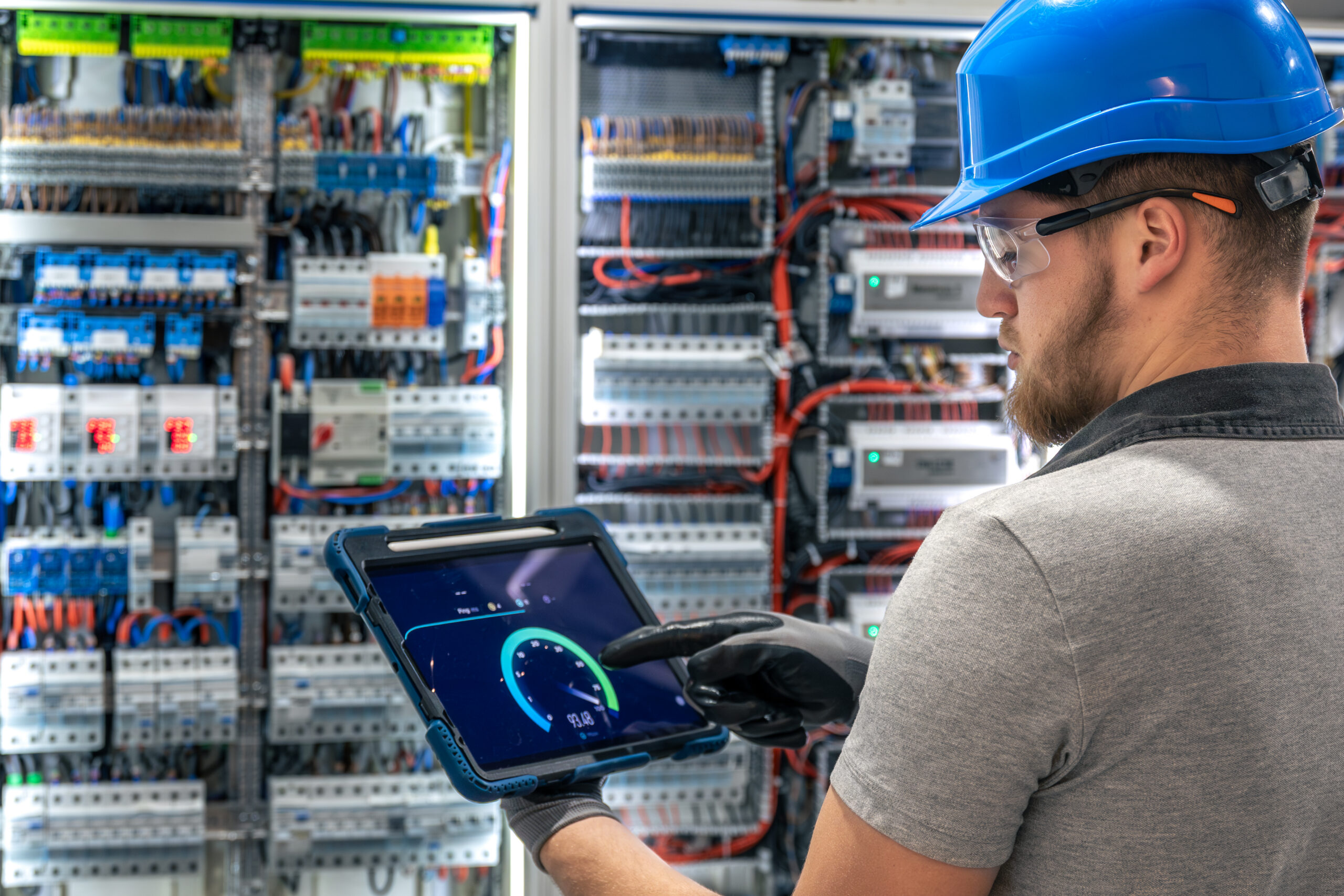 Ein Techniker &uuml;berwacht mithilfe eines Tablets die Kennzahlen einer komplexen technischen Anlage &ndash; ein Bild f&uuml;r Verantwortung, Pr&auml;zision und wirksame Steuerung im Wandel.