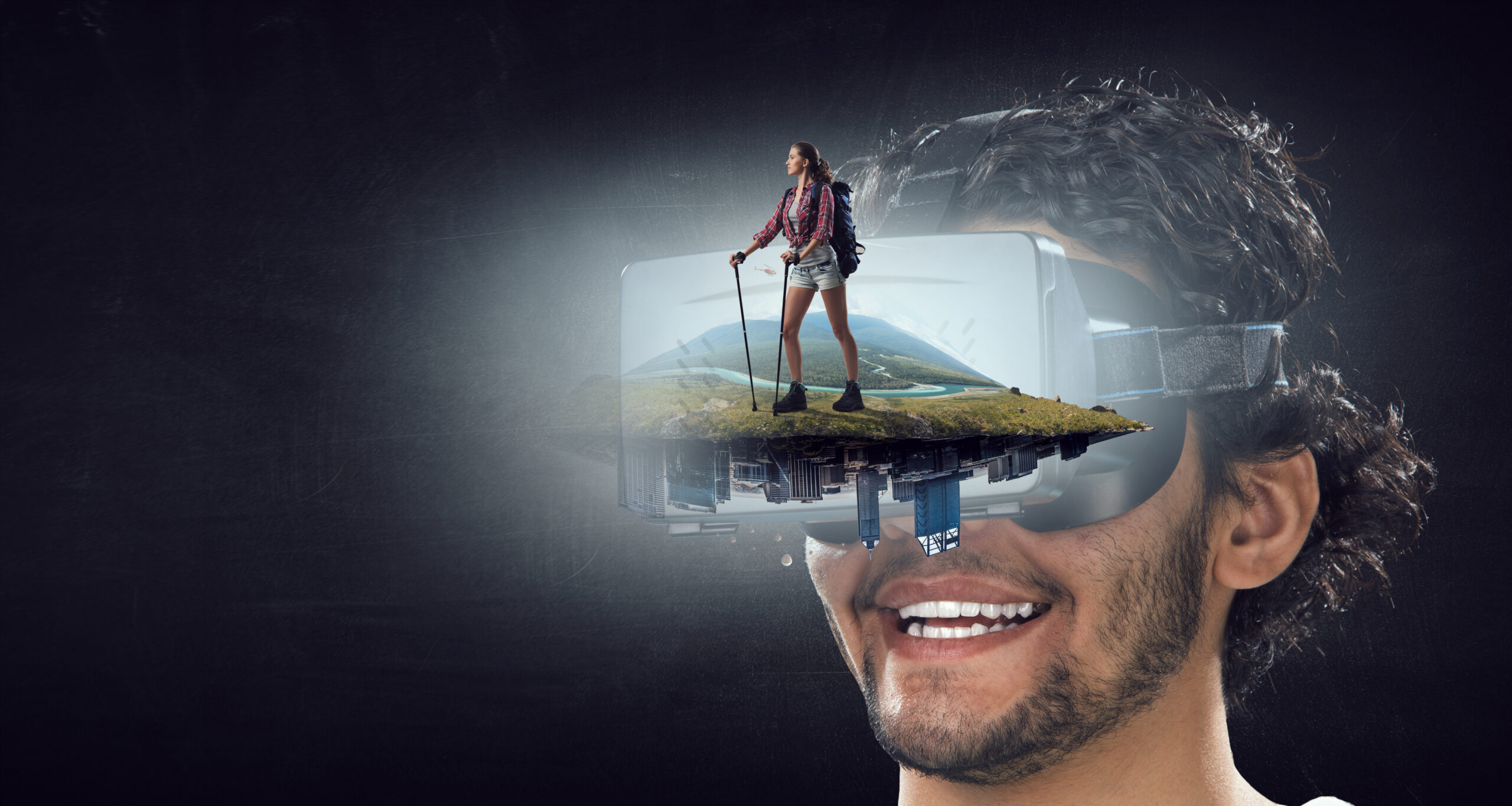 Ein l&auml;chelnder Mensch tr&auml;gt eine VR-Brille, in der eine wandernde Person in einer weiten Landschaft sichtbar wird &ndash; ein Sinnbild f&uuml;r Zukunft, Perspektivwechsel und neue Horizonte.